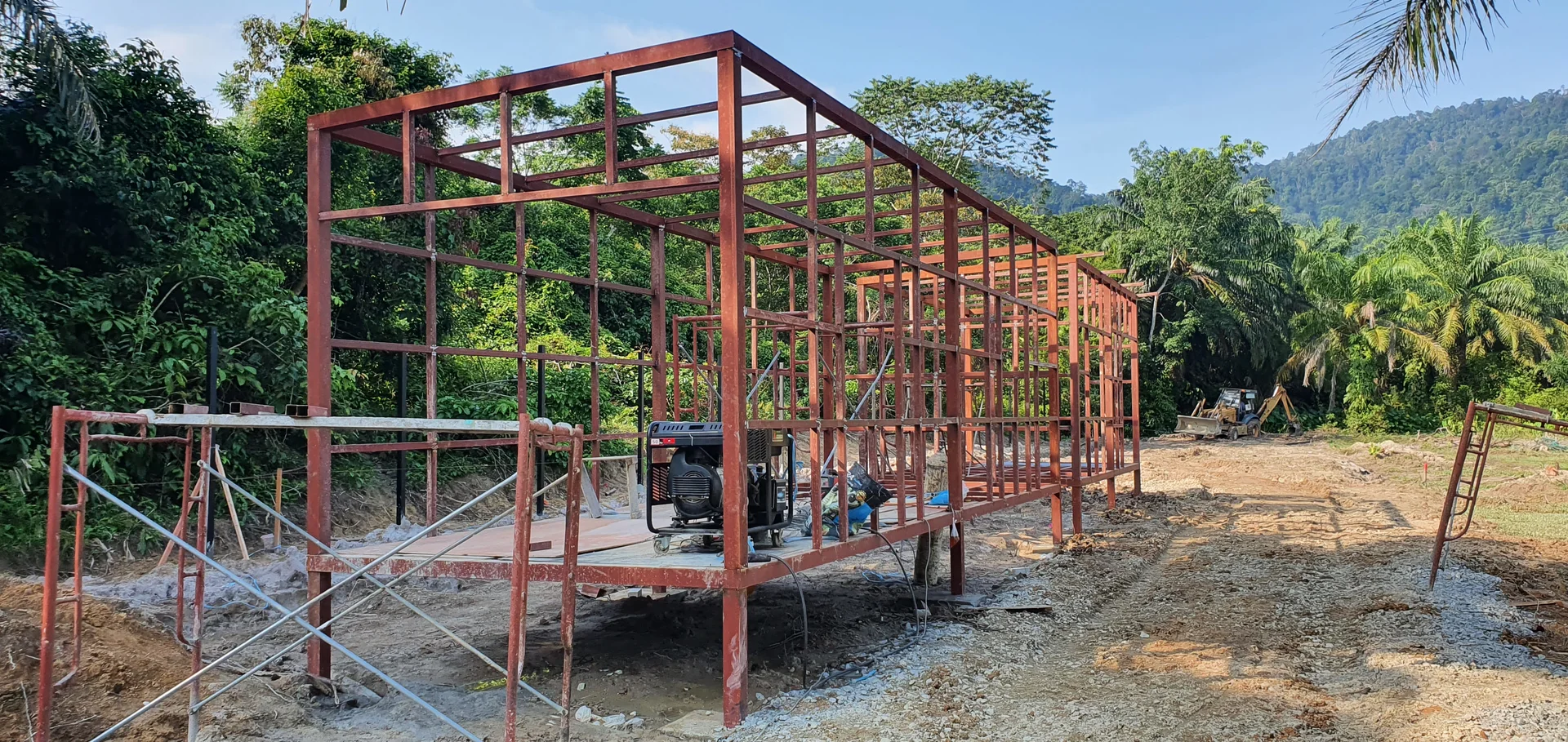 Steel frame of the first structure standing on raw cleared land